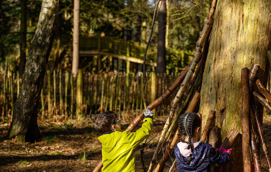 Two children begin building a den at BeWILDerwood