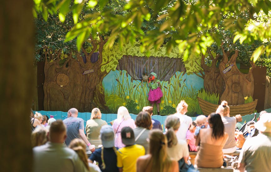 An audience watches a story at the Storytelling Stage in BeWILDerwood Norfolk