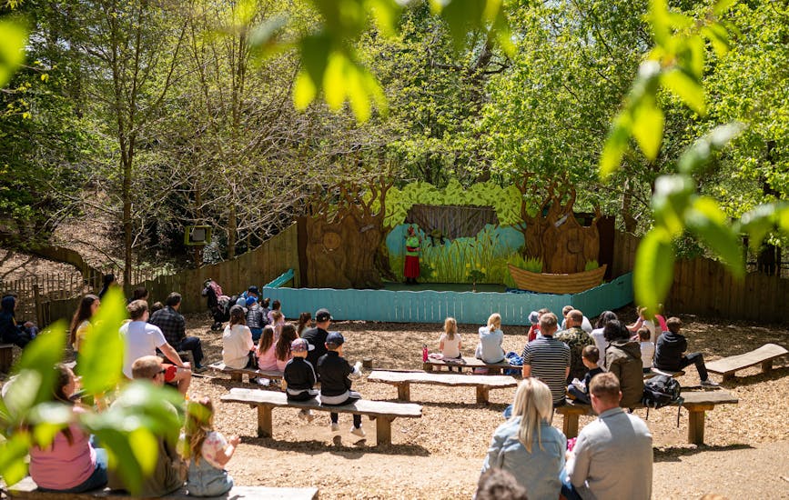Families watch a perfomance at the Storytelling Stage in BeWILDerwood Norfoll