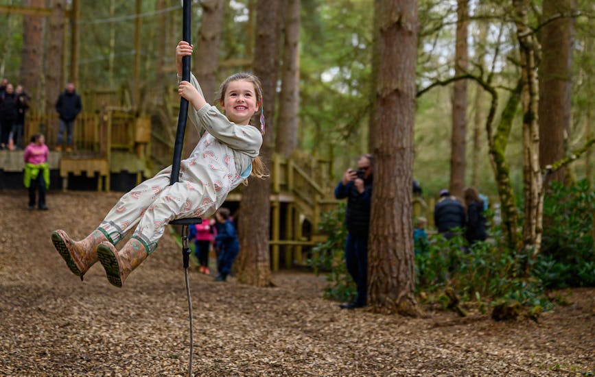 A child plays on a zip line at BeWILDerwood