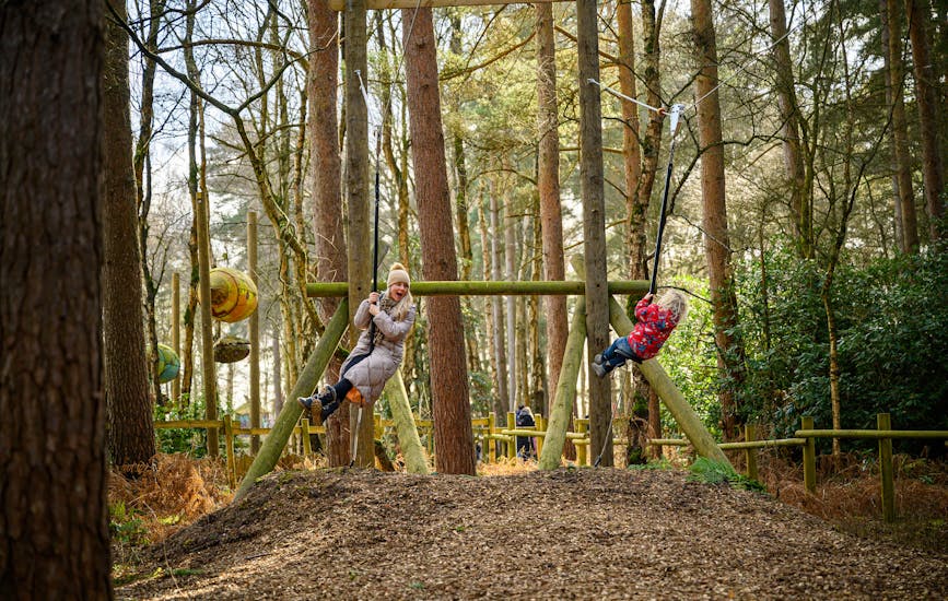 A mother and child play on the zip lines at BeWILDerwood Cheshire
