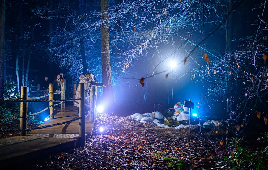 A family look at two snowmen in a boat at BeWILDerwood Presents Christmas