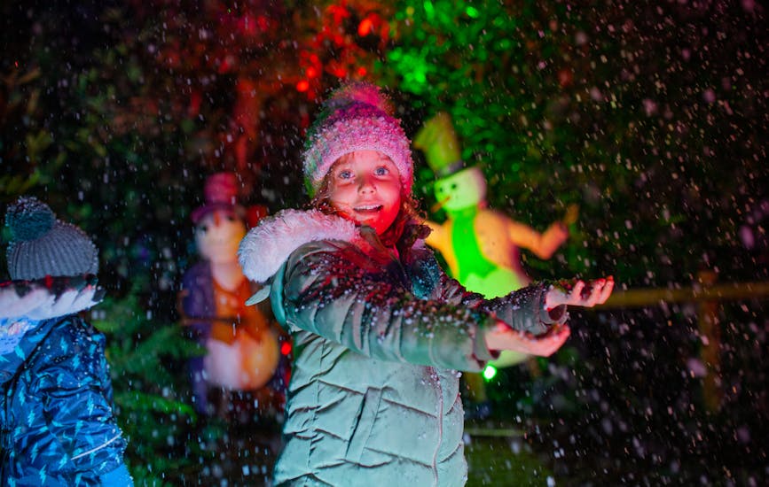 A child plays in the snowfall at BeWILDerwood Presents Christmas