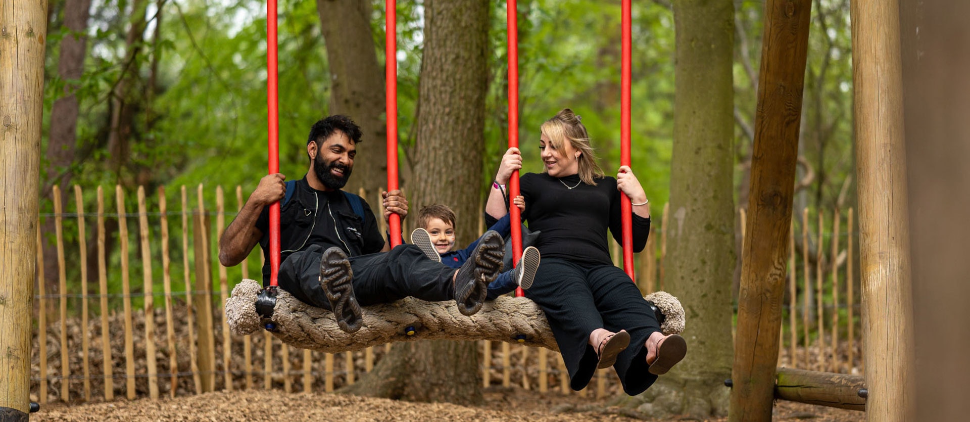 A family play on a swing together at BeWILDerwood Norfolk