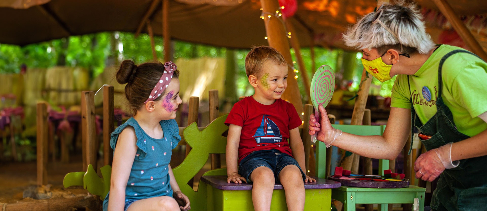 Two children smile at their face paint at BeWILDerwood