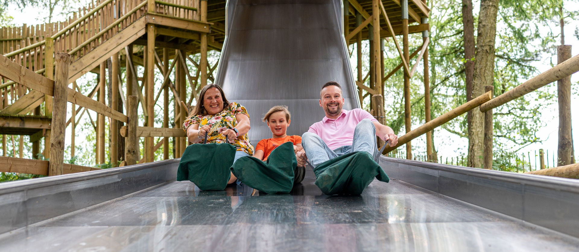 A family slide down a big slide at BeWILDerwood