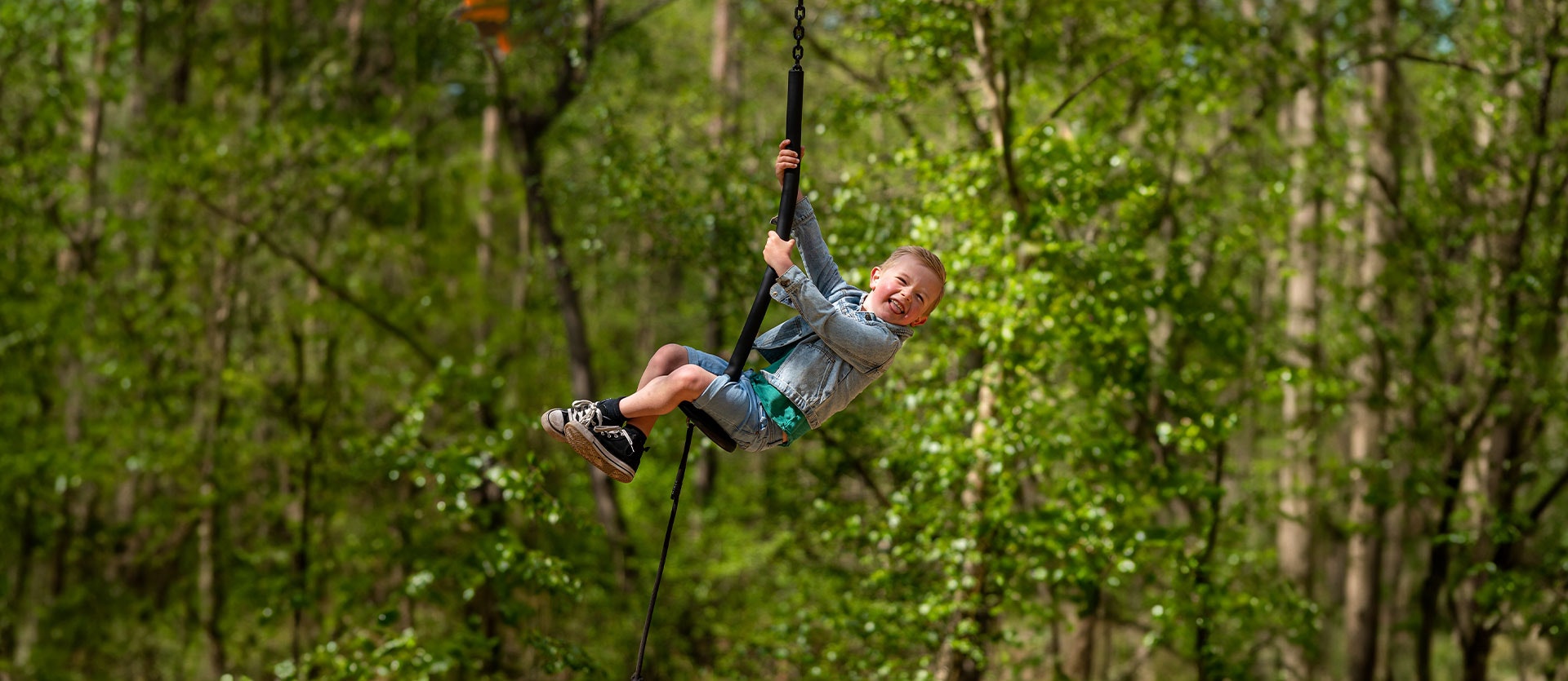 A child plays on a zip line in BeWILDerwood